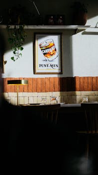 Sunlit restaurant interior with vintage wall poster and shadows casting a warm ambiance.