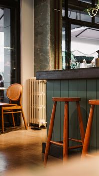 Warm and inviting café interior featuring wooden stools and chairs with atmospheric lighting.