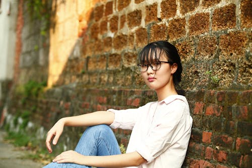Woman Leaning on Bricked Wall