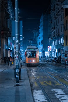 Vibrant night view of a tram on Milano street, highlighting city life and urban transit.