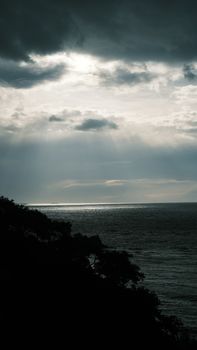 Captivating image of the ocean under dramatic clouds with sun rays breaking through