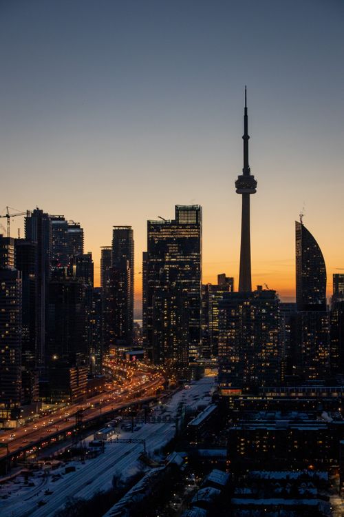Free Captivating view of Toronto's skyline at dusk featuring the iconic CN Tower amidst skyscrapers. Stock Photo