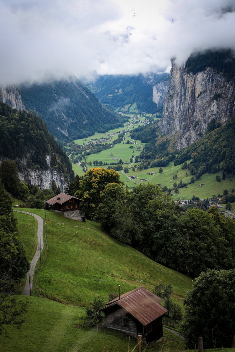 Huts In A Valley Surrounded By Tall Cliffs