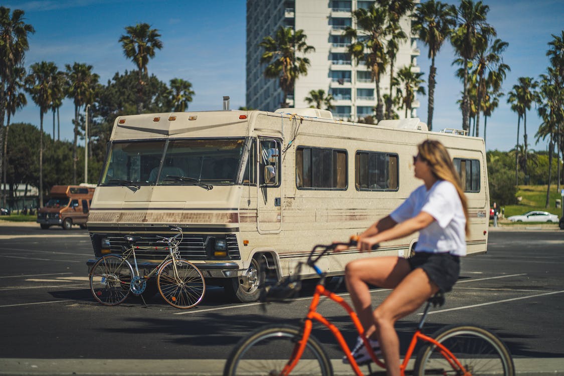 Femme devant un camping car a vélo