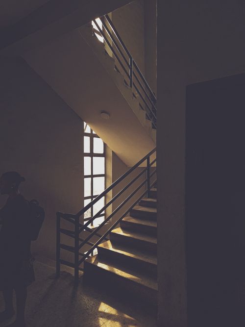 Free A moody, dimly lit staircase with strong shadows, creating an artistic ambiance. Stock Photo