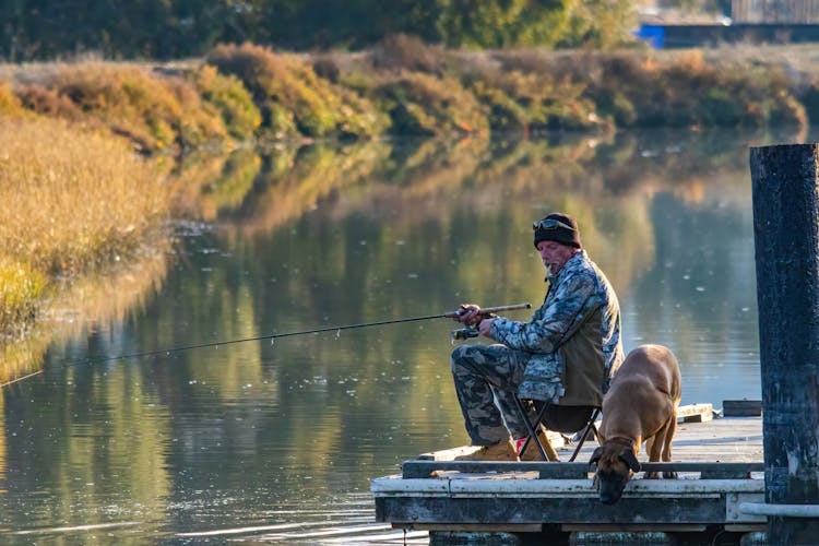 Man Fishing With Dog