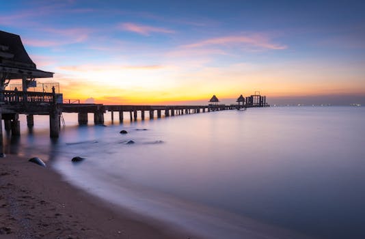 Tranquil sunset view of a pier extending into the sea, captured in Bangkok, Thailand.