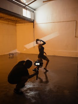 A stylish fashion shoot indoors featuring a cameraman capturing a model's dynamic pose.