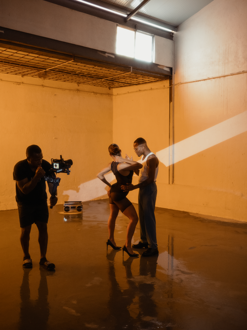 Free Photographer shooting a couple posing in an industrial-style studio setting. Stock Photo