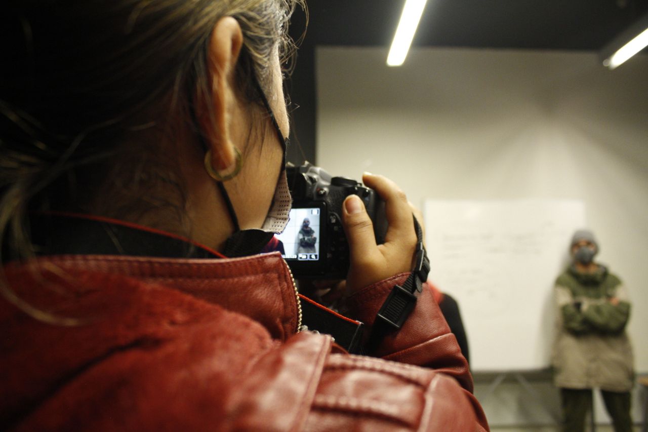 a female photographer taking a picture in a studio environment with a