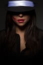 在黑暗的工作室里，一位戴着黑色帽子的神秘女子，唇上留着红色口红印