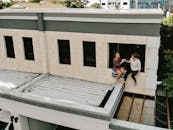 在澳大利亚西澳的苏比亚科，两名女子坐在一座城市建筑上享受片刻