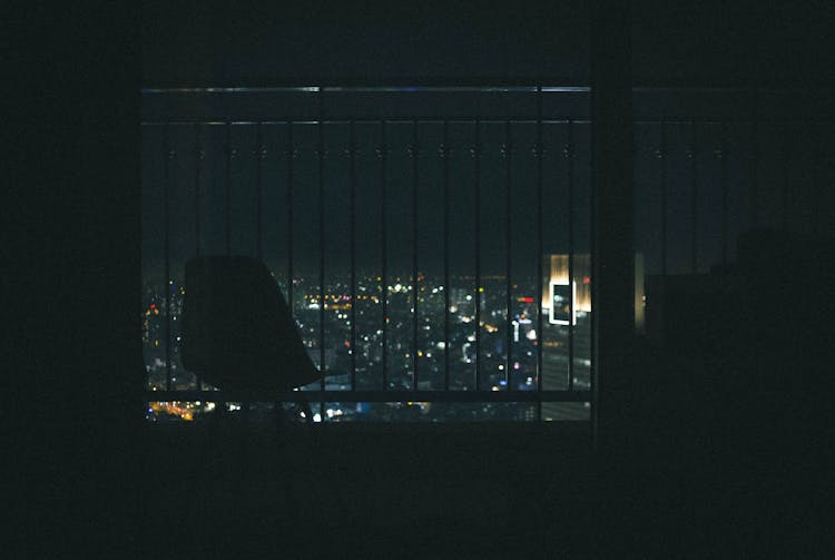 Silhouette Of Chair Near Window Grille