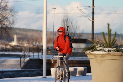 Man in Red Jacket Riding a Bicycle