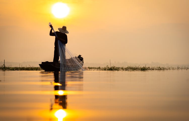 Farmer On Boat At Sunset