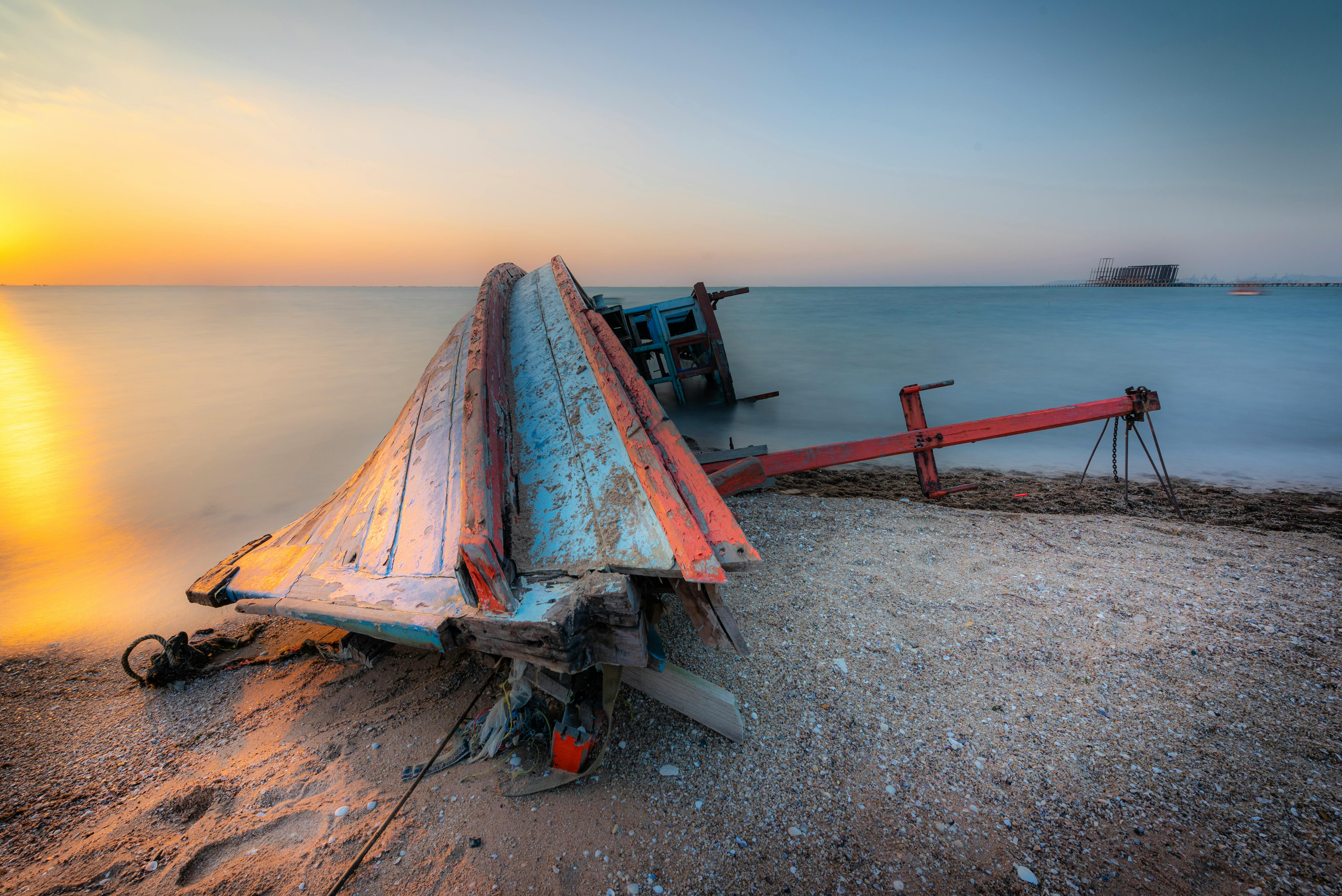 Peaceful sunset scene with a shipwreck on the coast of Thailand, embodying tranquility and history.