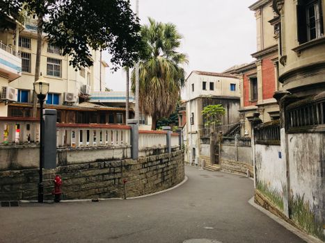Tranquil narrow street with vintage buildings and a palm tree highlighting historic urban charm.