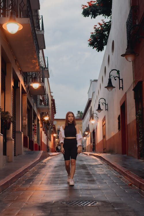 Woman Walking on Street in Town