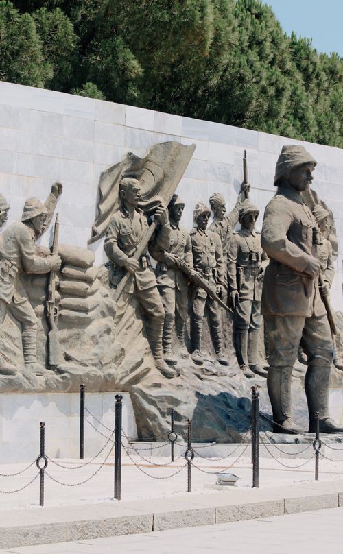 Free A stone sculpture depicting soldiers in a historical battle scene outdoors. Stock Photo