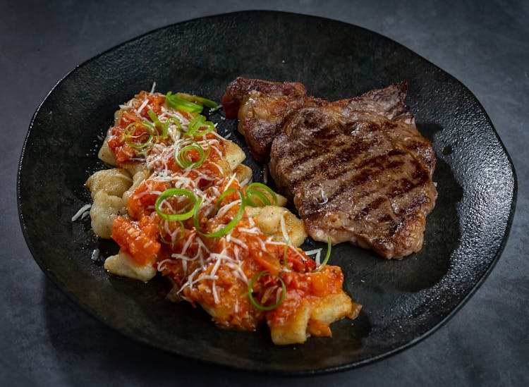 Pork Steak On Black Ceramic Plate