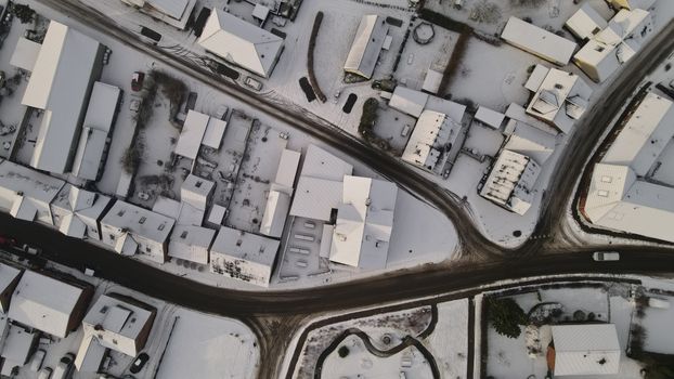 Drone shot of snow-covered houses and roads in Uldum, Denmark during winter.