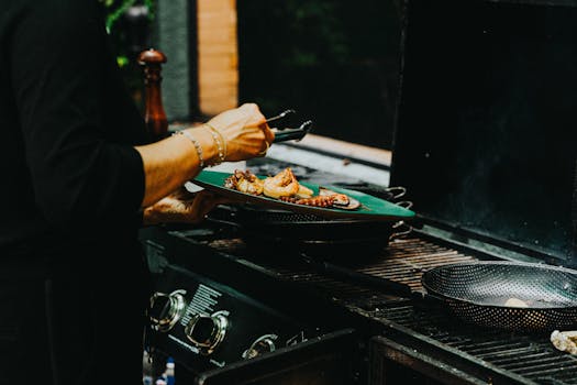 Close-up of a chef grilling prawns and octopus on an outdoor barbecue grill.