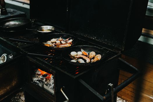 Delicious seafood grilling over an open flame on an outdoor stove, showcasing culinary craftsmanship.