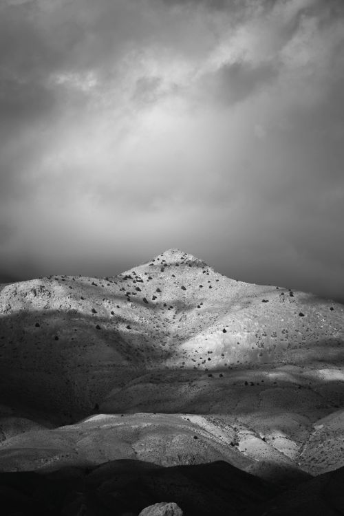 Free Captivating black and white image of a mountain under dramatic clouds. Stock Photo