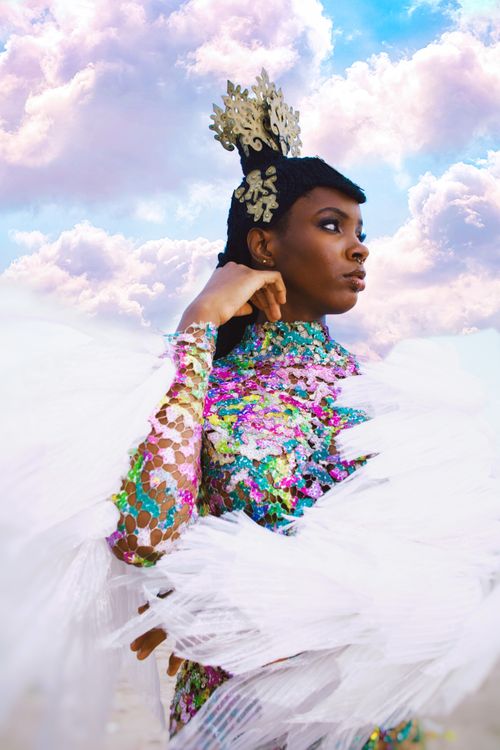 Free Elegant woman in colorful attire posing with a tiara against a cloudy sky in Lagos, Nigeria. Stock Photo