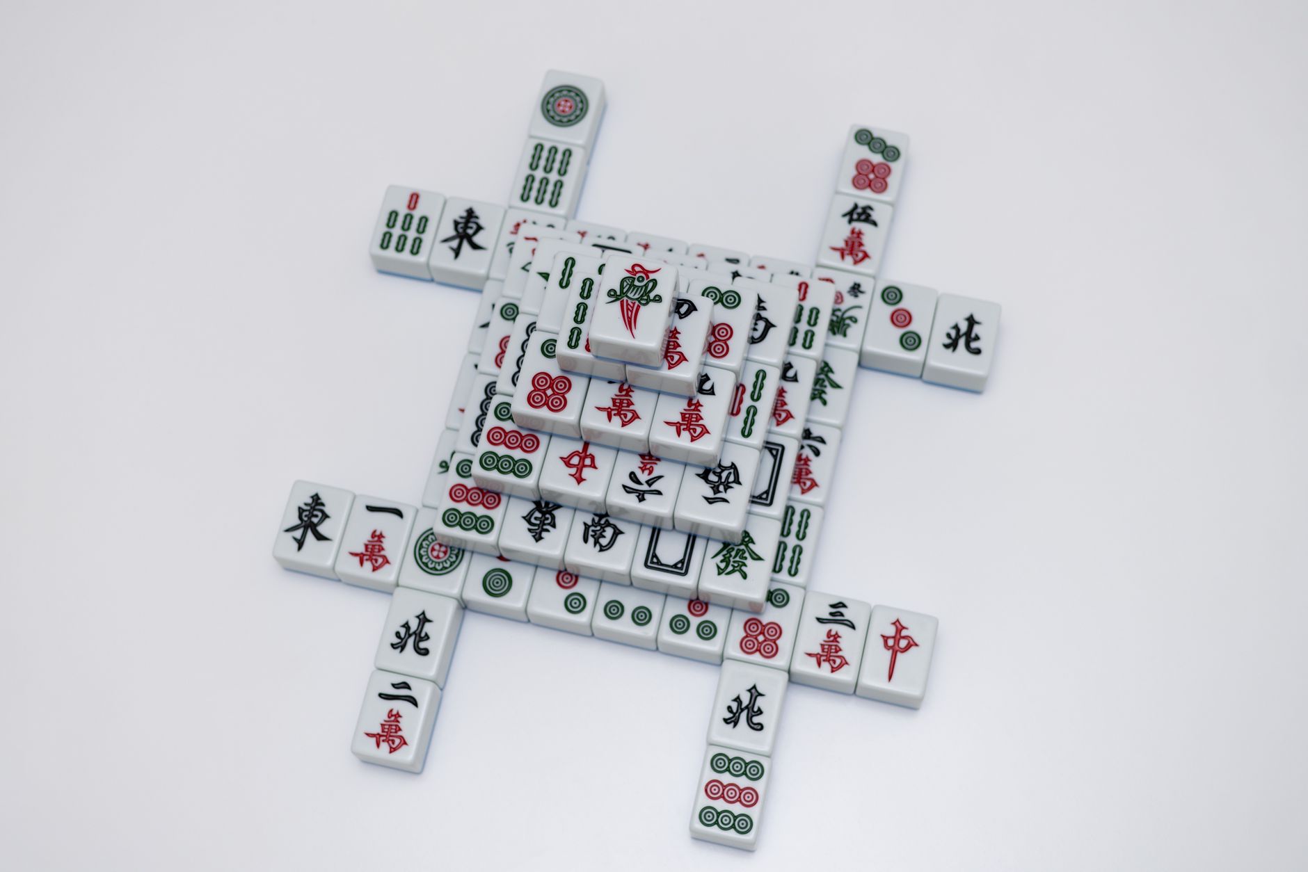 Intricately stacked mahjong tiles on a white background, showcasing traditional design.