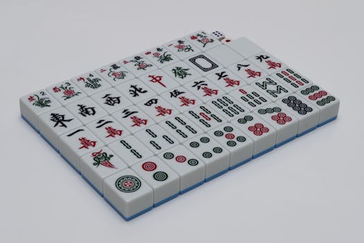 A set of mahjong tiles neatly arranged on a white background, ideal for gaming enthusiasts.