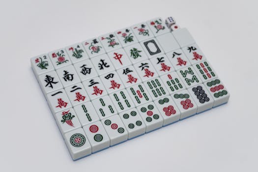 A detailed view of Mahjong tiles arranged on a white background, showcasing traditional Chinese symbols.