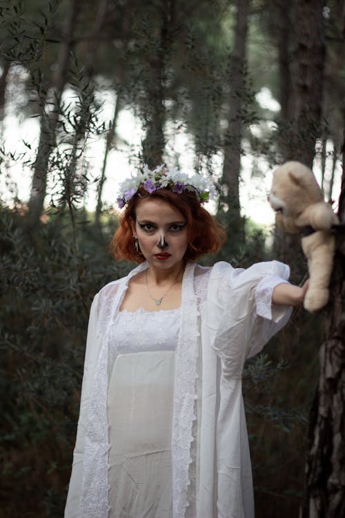 Woman in White Dress with Teddy in Forest