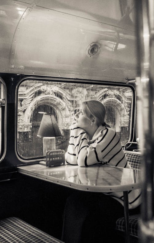 Woman Sitting at Table near Window in Bus