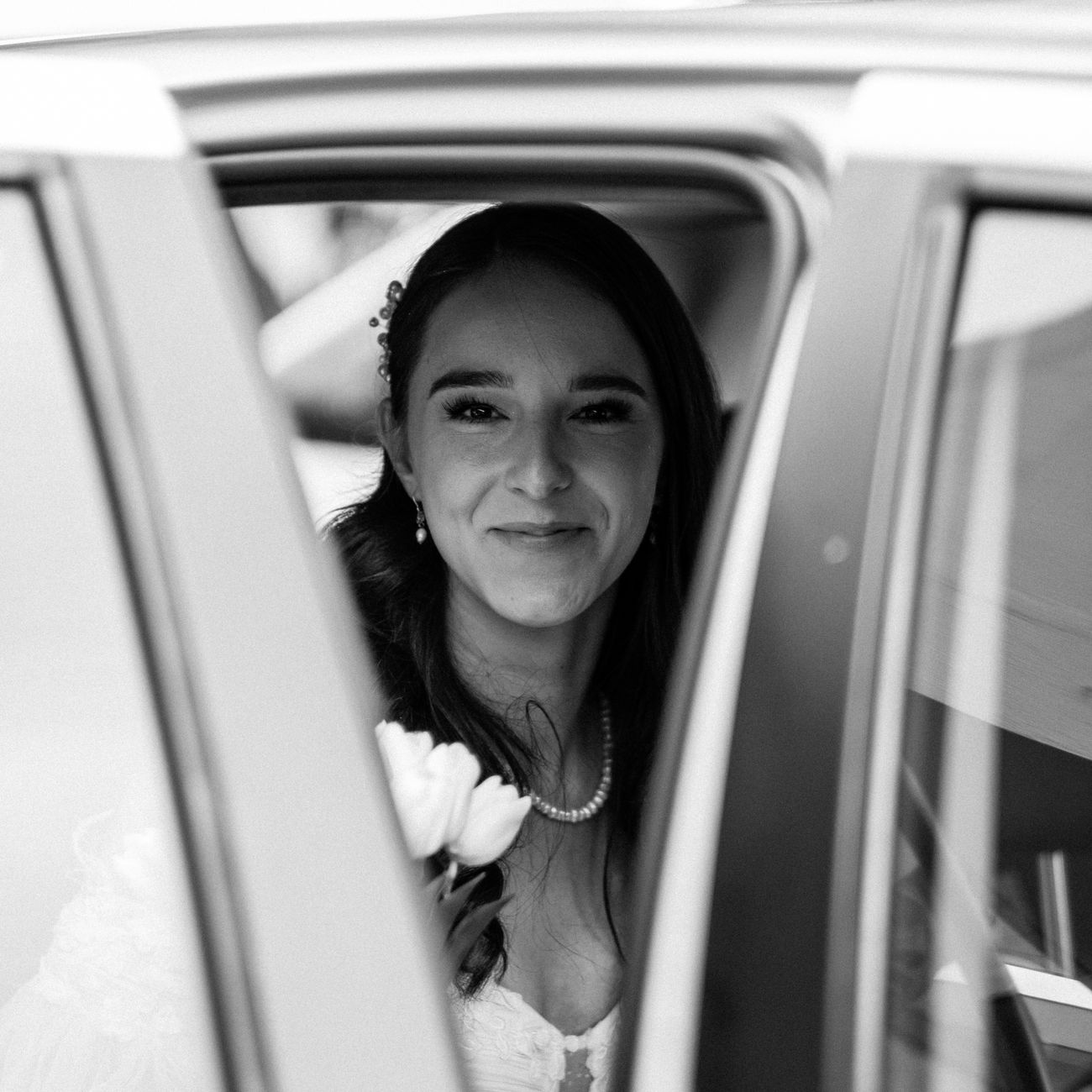 Smiling bride in a car window during a wedding in Antalya, Türkiye.