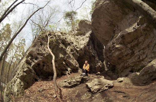 Woman Sitting near a Sandstone Formation in a Forest