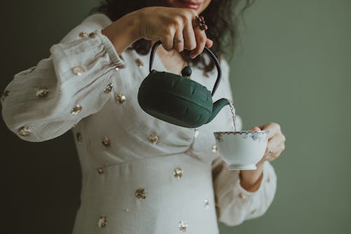 Photo of Woman Pouring Water in the Cup