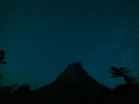 Stunning view of the starry night sky with a silhouetted hill, perfect for nature and astronomy enthusiasts.