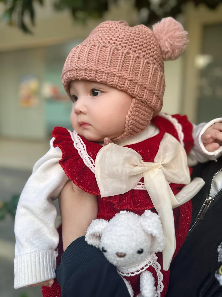 Cute Baby In Hat In Parent Arms