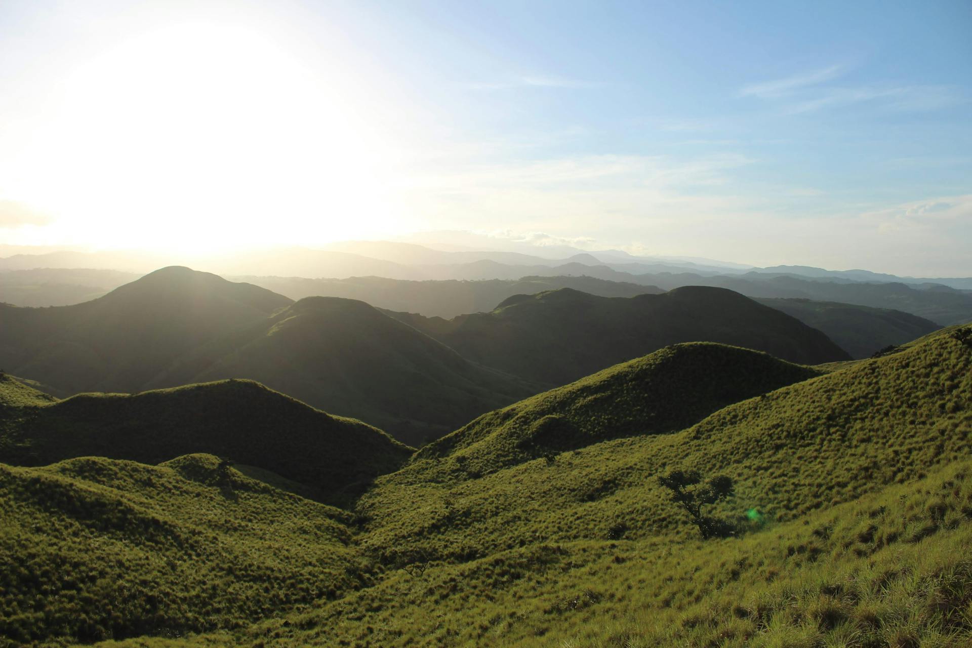 Scenic view of sunlit rolling hills in Guanacaste, Costa Rica at dusk.