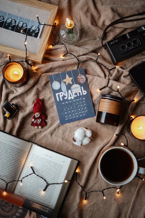 View of a Cup of Tea, Book, Candles and Other Items Lying on a Blanket 