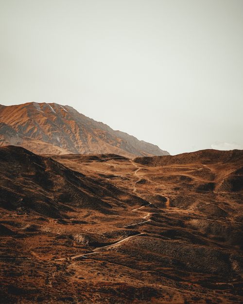 Free A stunning view of an arid mountainous landscape with a dramatic sky, captured at dusk. Stock Photo