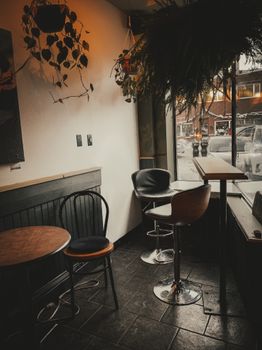 Warm and inviting corner of a café featuring seating and a snowy street view.