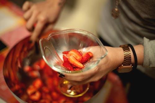 Person Holding Goblet Glass With Slice Strawberries