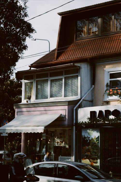 Free Charming urban street scene featuring a small shop and residential building captured in natural light. Stock Photo