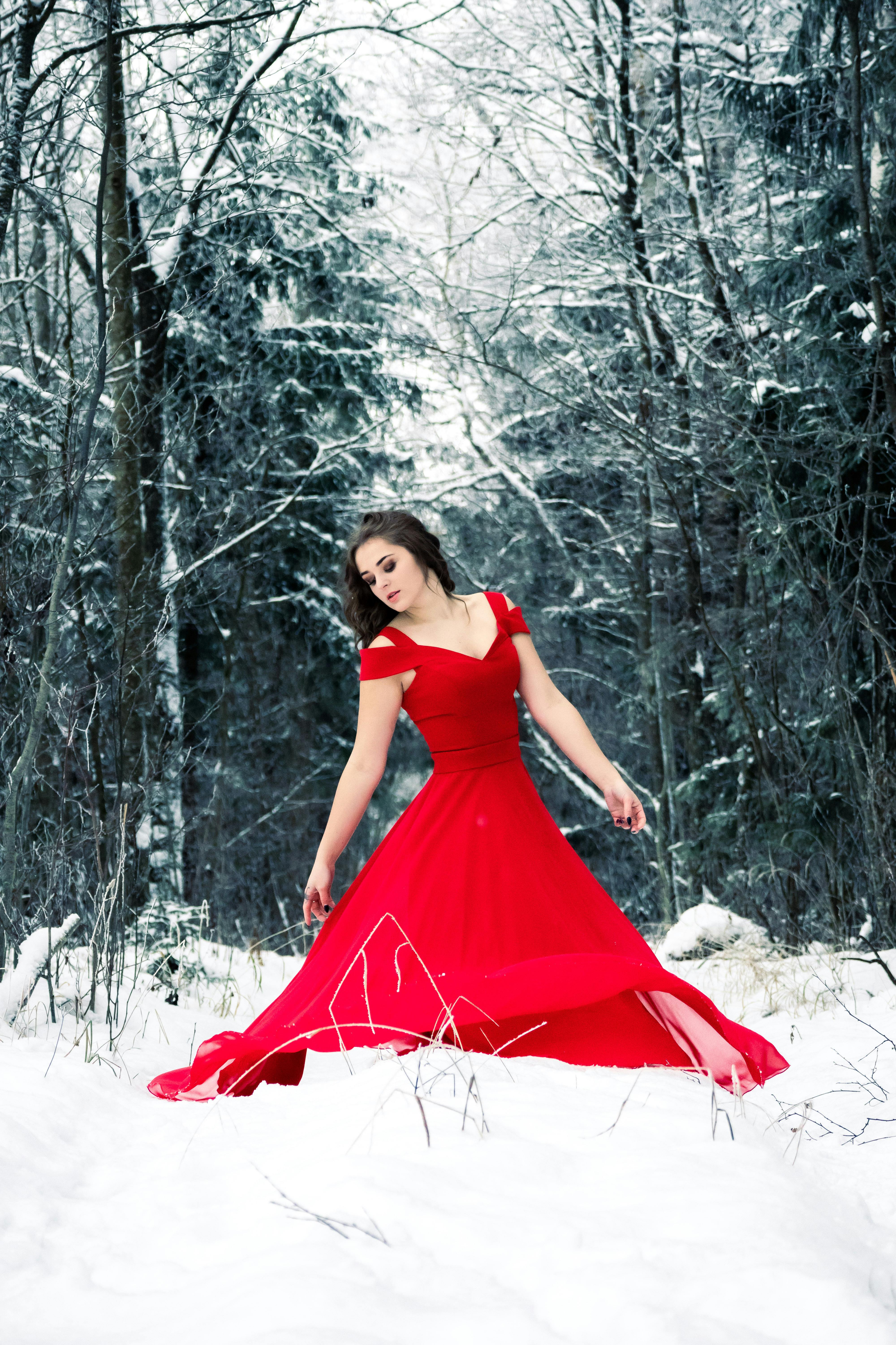 A Woman Wearing a Red Dress in a Forest during Winter Free Stock Photo