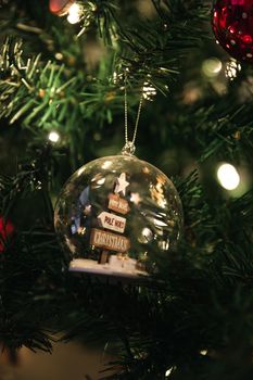 A close-up of a Christmas tree with a decorative snow globe ornament, perfect for holiday decor.