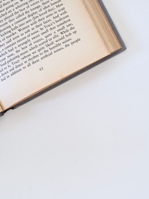 Close-up of a book open to page 61 with text visible against a white background.