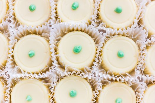 Appetizing close-up of creamy vanilla cupcakes with green icing topping, perfect for dessert ideas.