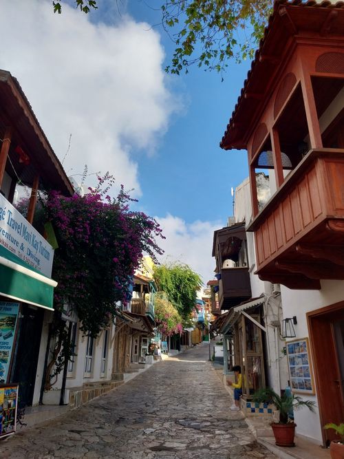 Free Quaint urban street with traditional wooden balconies and vibrant flowers under a bright sky. Stock Photo